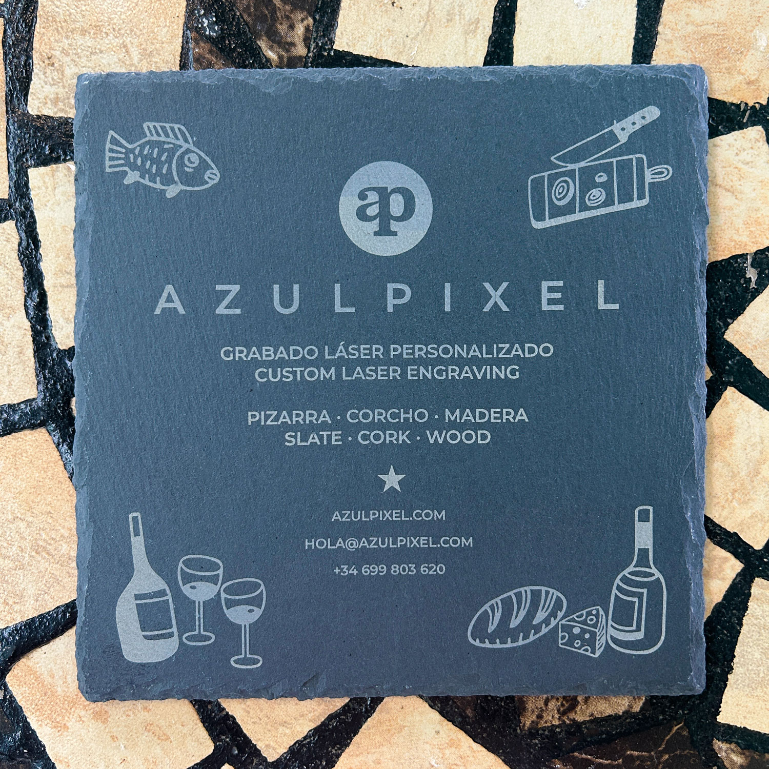 Branded slate coaster with engraved logo and illustrations
